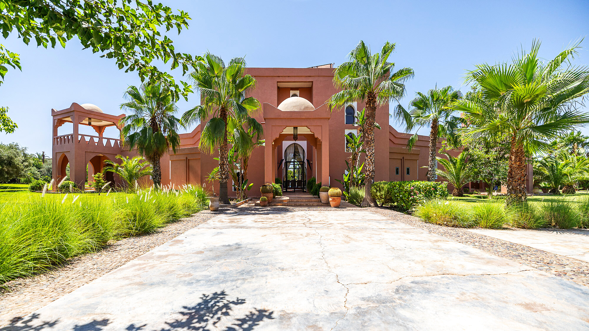 Main façade and palm-lined approach